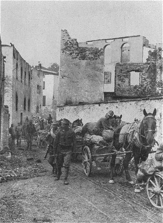 Der 1. Weltkrieg: Eine sterreichisch-ungarische Kolonne zieht durch die zerstrte Ortschaft Rundschein (Sdtirol)